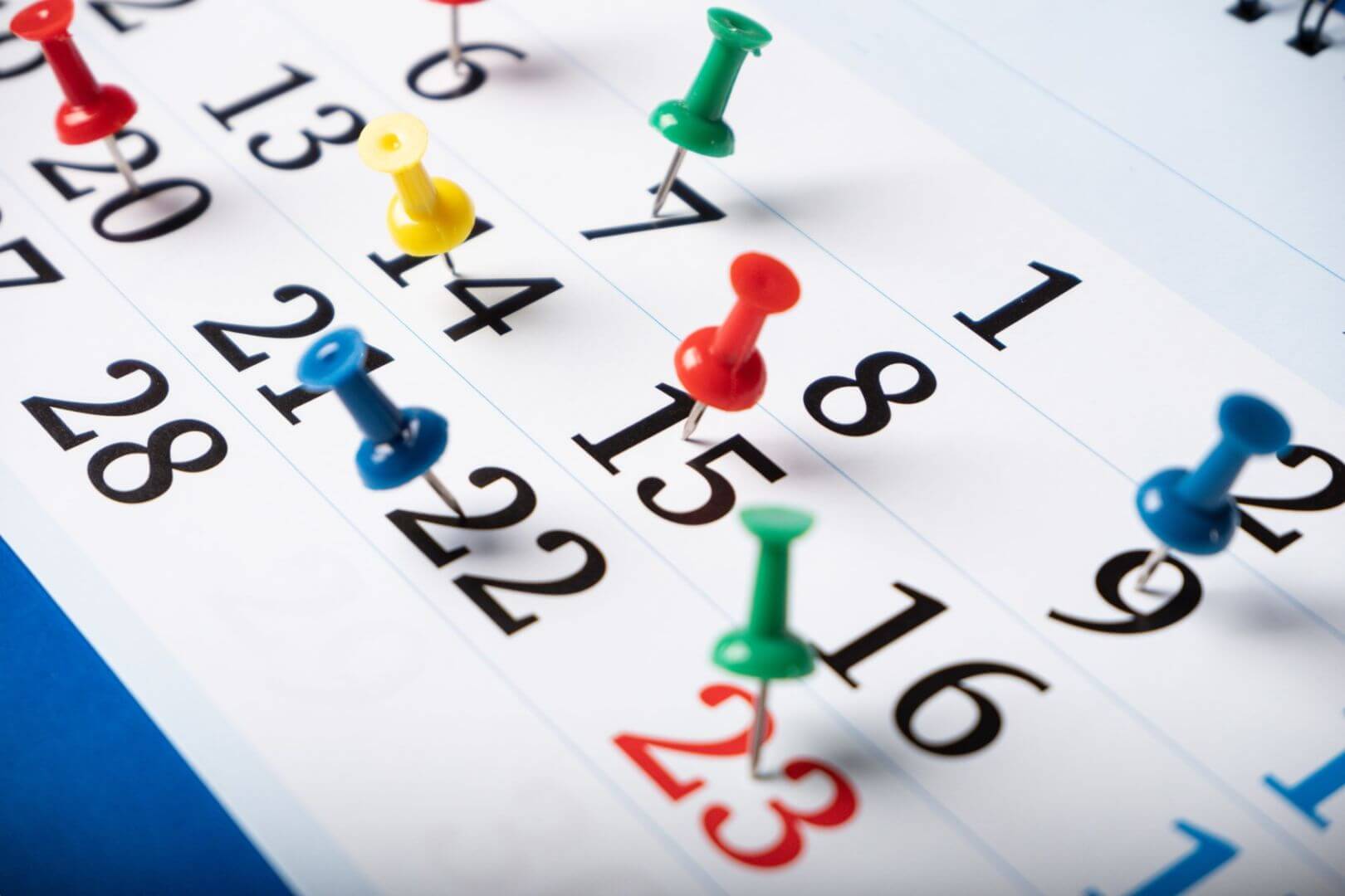 Photograph of a calendar with push pins in it